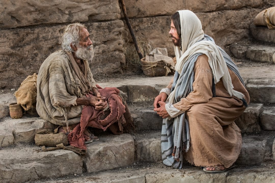 Escena de película en que Jesús habla con un pobre paralítico