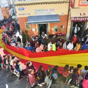 Tomares saca en procesión una bandera de España gigante portada por niños para celebrar el día de la Constitución